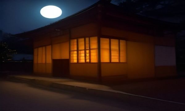 一位独立设计师坐在工作室内浏览午夜导航设计资源类目，屏幕上显示字体与素材分类页面，工作台上摆放手绘草稿